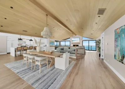 A living room and dining room with a view of the ocean.