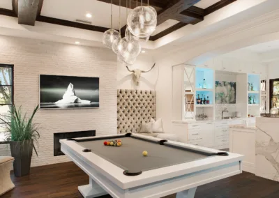 A room with a pool table and a fireplace.