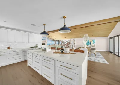 A kitchen with white cabinets and a wooden floor.